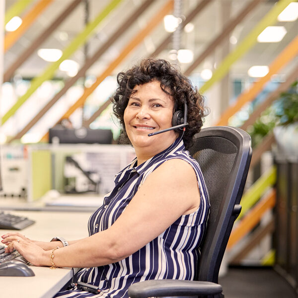 Lady sitting at computer with headphone micorphone on head