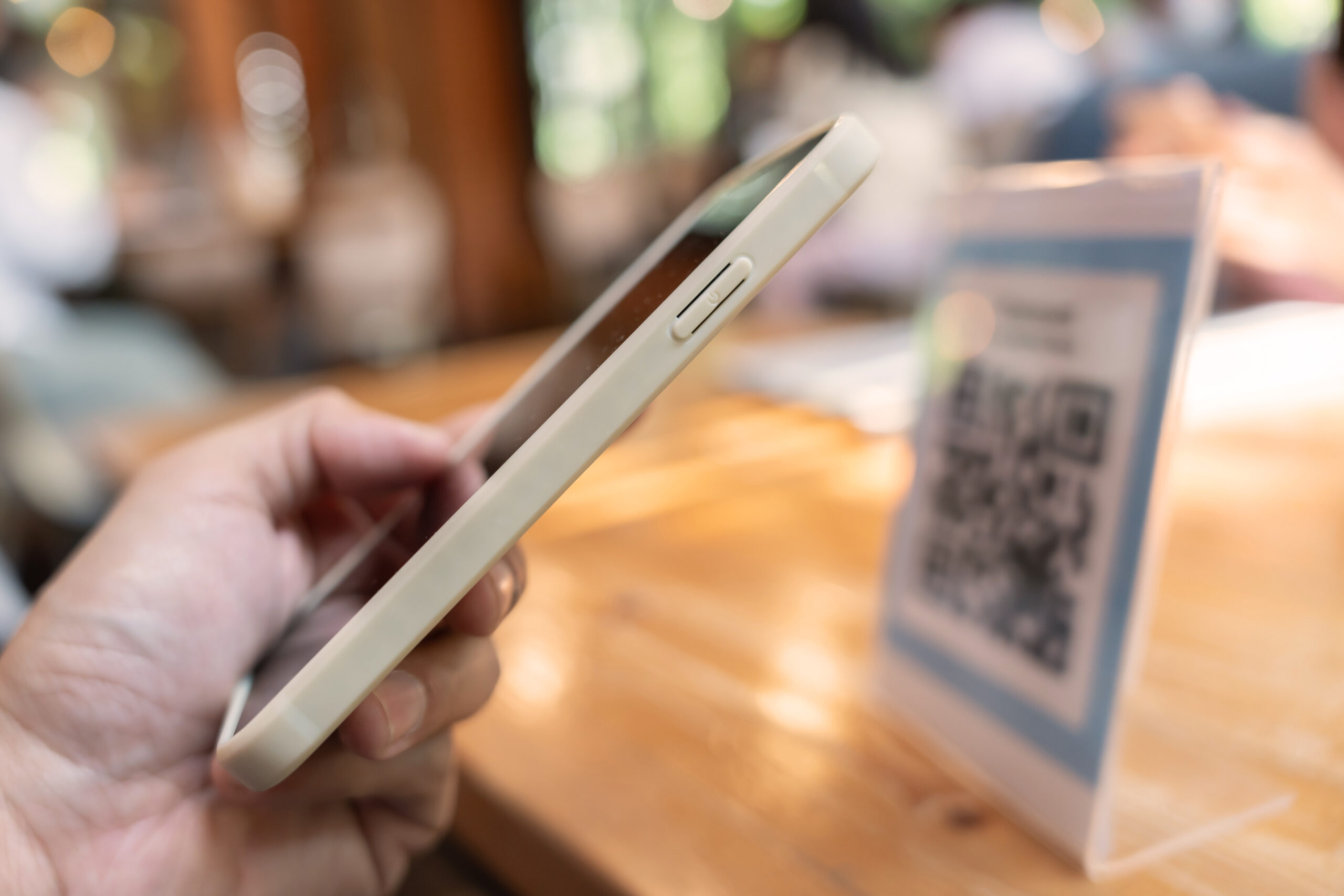 Hand holding a smartphone to scan QR code