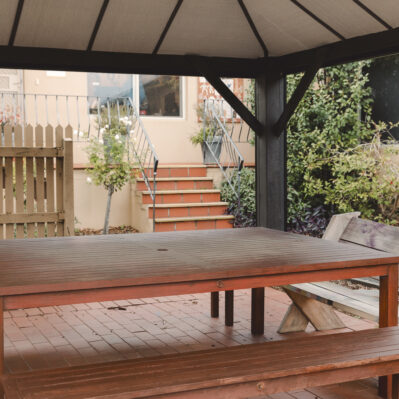 A courtyard containing an undercover space with an outdoor table.