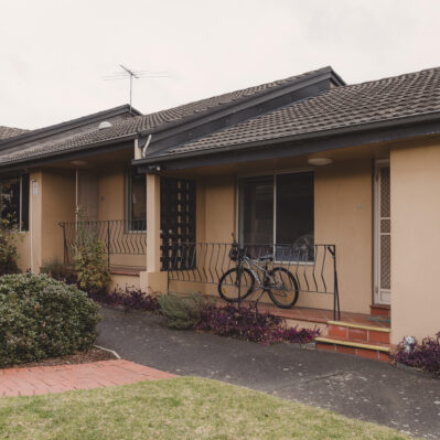 Two adjoining units, each with a small garden out the front. One has a bicycle on the front patio.