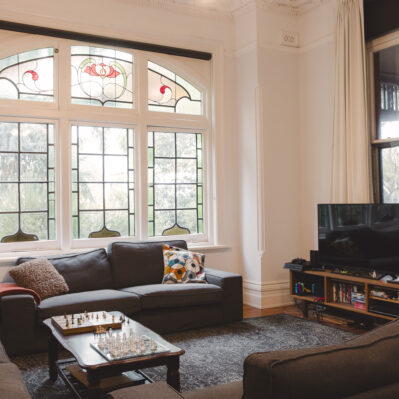 Comfy couches arranged around a coffee table with games of chess in progress. Against the wall is a TV unit with various gaming consoles, games and a TV.