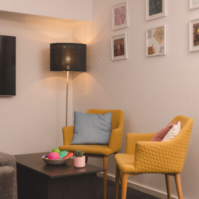 Stylish chairs arranged around a small coffee table, on top of which is a succulent and a small tray of sensory toys.