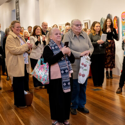People applauding speaker at exhibition launch.