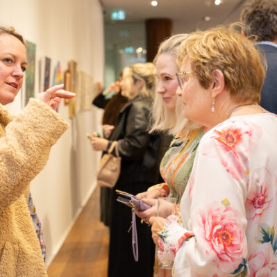 People speaking with each other at exhibition launch.